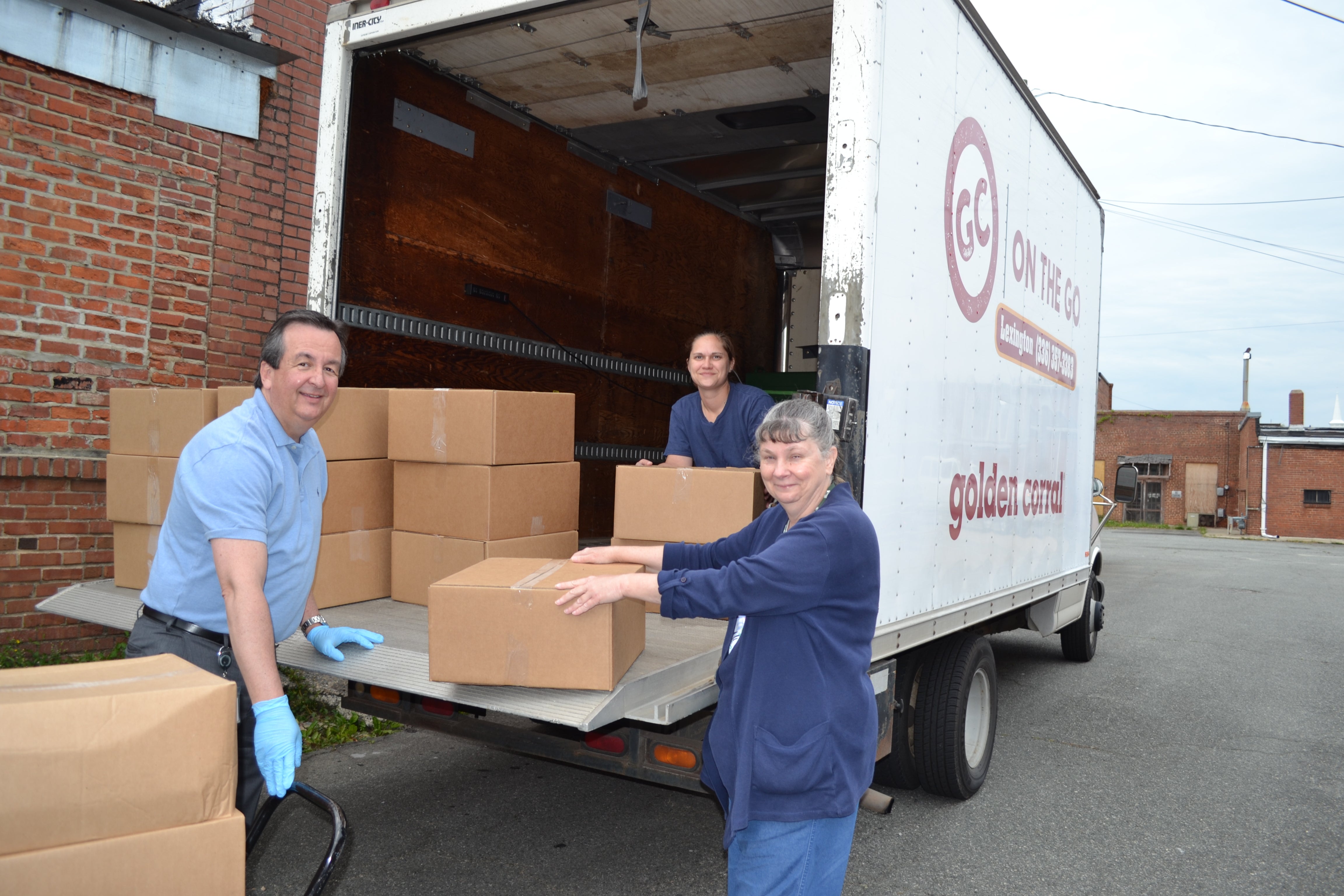 Man and women loading boxes in truck