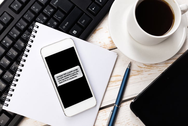 phone sitting on desk with outage alert on screen